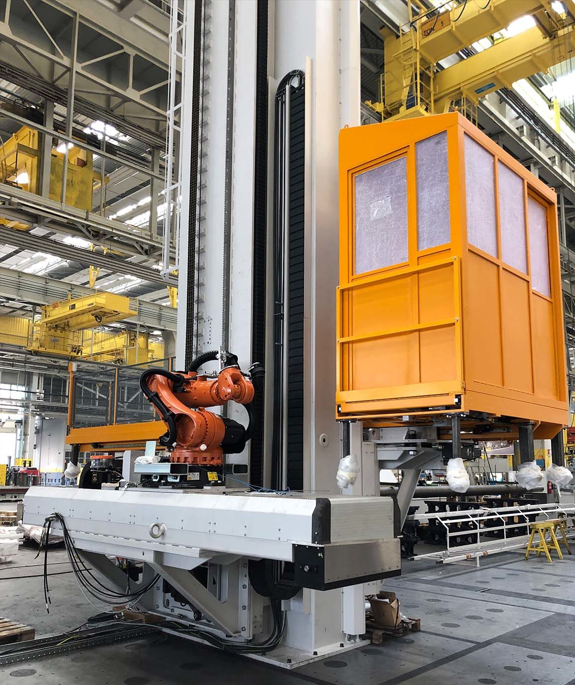 Column with lifting double carriage for the robot handling and operator cab in a large machining center.